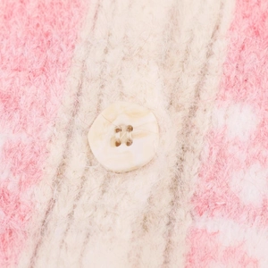 Close-up of fluffy pink and white striped knit vest with a marble-pattern button