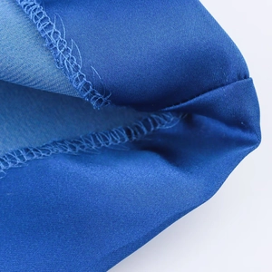 Close-up of the detailed hem stitching and blue satin texture on the shirt sleeve