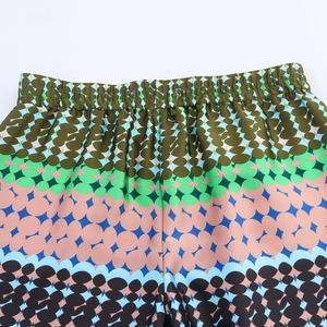 Detailed view of elastic waistband on printed satin trousers with geometric pattern