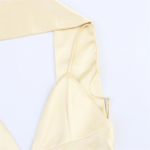 Détail de l'encolure en satin champagne avec fines bretelles et texture soyeuse