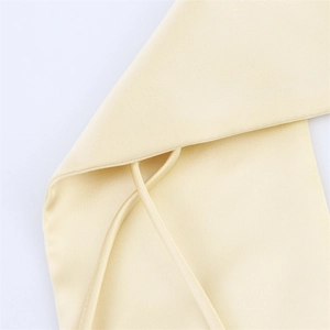Gros plan détaillé de la bretelle en satin crème et de la texture tissée fine