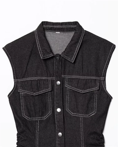 Detail of black denim vest with white contrast stitching and metallic buttons