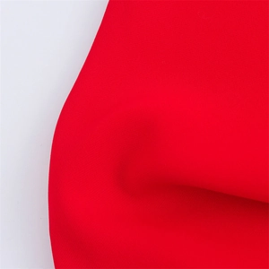 Close-up of bright red midi dress fabric showing high-quality woven texture and finish