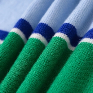 Close-up of a striped knit polo sweater in blue, white, and green textured fabric