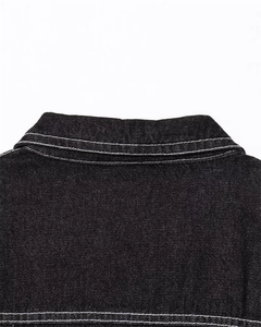 Detail of white contrast stitching and denim texture on back collar of black denim dress