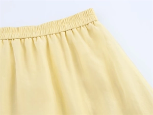 Détail de la jupe transparente jaune clair montrant la taille élastique plissée
