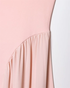 Détail du tissu tricoté rose clair montrant la texture douce et les coutures plissées
