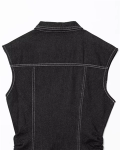 Detail of dark denim vest showing contrast stitching and high-quality fabric texture