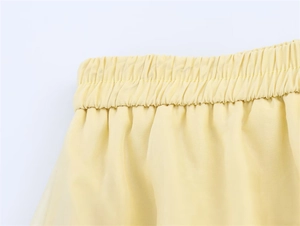 Détail de la taille élastique à volants sur une jupe en mousseline jaune crème diaphane