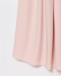 Vue détaillée de l'ourlet de la jupe en maille rose clair avec texture soyeuse