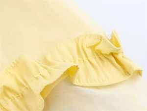 Détail de l'ourlet à volants jaunes transparents et coutures professionnelles de la jupe