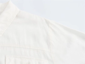Detailed close-up of white cotton linen shirt dress collar and shoulder seam craftsmanship