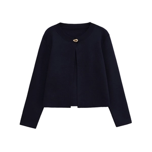 Détail d'un cardigan en maille bleu marine avec tissu texturé et bouton doré décoratif