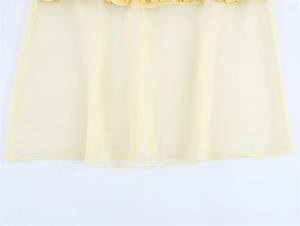 Détail macro du tissu mousseline jaune clair transparent avec ourlet et couture plissée