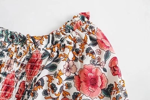 Dettaglio della vita a punto smock su un abito estivo leggero a fiori rosa
