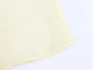 Détail de couture sur tissu léger jaune clair avec finition délicate de bord volant