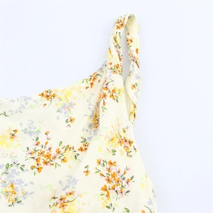 Détail de la bandoulière torsadée et de l'imprimé floral sur une robe en satin léger