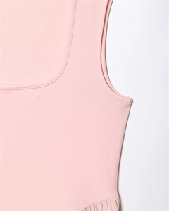 Détail de l'encolure carrée et des fronces sur une robe en maille rose sans manches
