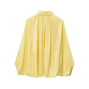 Détail de la veste jaune pâle présentant un col montant plissé et des manches bouffantes