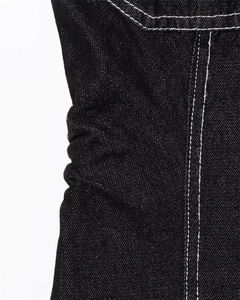 Detail of black denim dress featuring ruching and white contrast stitching on fabric