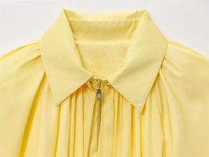Gros plan détaillé du col d'une blouse jaune vif avec fermeture éclair dorée chic