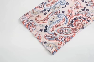 Detailansicht des Paisley-Muster-Drucks auf rosa Satinstoff mit hochwertigen Nähten