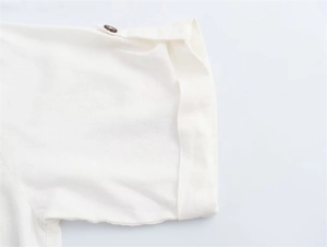 Close-up of rolled sleeves with wooden buttons on white cotton linen midi dress