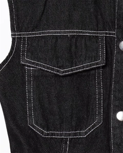 Macro detail of black denim vest with contrast white stitching and silver metal buttons