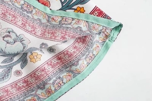 Dettaglio di un abito boho floreale con motivi rosa e rifiniture a doppia cucitura