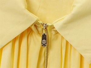 Vue macro de la veste bomber jaune avec fermeture éclair métallique gravée de motifs floraux