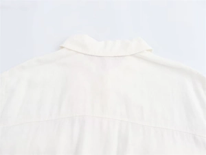 Close-up of the back yoke and collar stitching on a beige cotton linen midi shirt dress