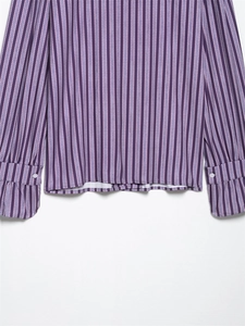 Detail of purple vertical stripe shirt showing fabric texture and buttoned cuff design