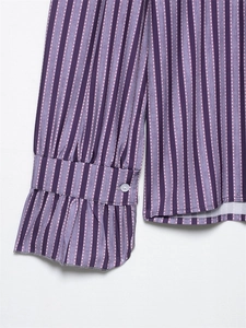 Close-up of ruffle cuffs and white button on purple striped long sleeve blouse
