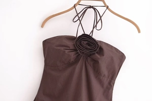 Detail of a dark brown halter top featuring a large 3D fabric rose decoration