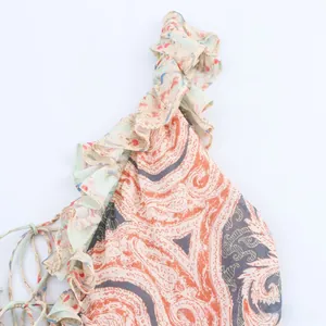 Détail de l'imprimé paisley sur tissu mousseline avec volants et cordons de serrage