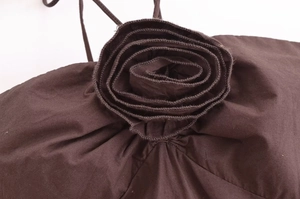 Detail of 3D fabric flower on dark brown dress featuring exquisite petal stitching