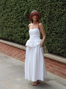 Detail of the white strapless maxi dress with elegant ruffles and a flared A-line skirt