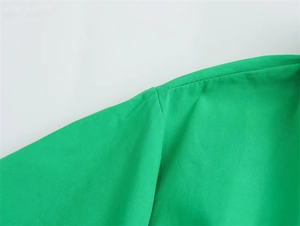 Detailaufnahme der Schulternähte und der Textur des grünen gewebten Hemdkleid-Stoffs