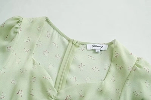 Detail von quadratischem Ausschnitt und Reißverschluss an hellem Blumenkleid