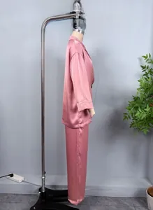 Detail of pink satin two-piece pajama set showing smooth texture and button-up lapel shirt