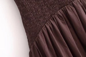 Close-up of brown halter dress featuring elastic smocked bodice and ruched fabric detail