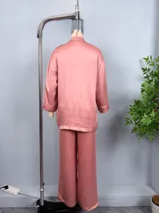 Detailed close-up of pink satin pajama set featuring a V-neck shirt and striped texture