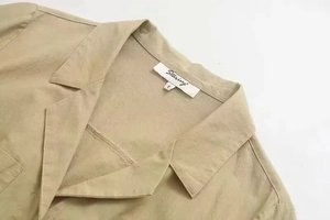 Close-up of khaki linen jumpsuit collar with Starivy brand label and size tag S