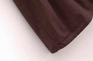 Detailed close-up of dark brown fabric texture and neat flat seam stitching