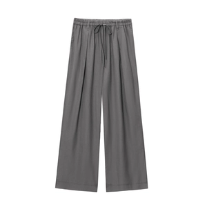 Détail du pantalon large en lin gris foncé avec taille élastique à cordon et plis