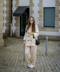 Detail of cream white double-breasted blazer and high-waisted wide-leg trousers suit