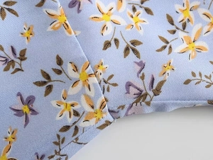 Détail du tissu en sergé bleu clair avec imprimé floral et coutures lisses