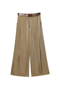 Macro detail of high-waist satin wide-leg trousers in golden brown with a leather belt