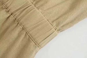 Close-up of khaki linen jumpsuit elastic waist with reinforced double stitching detail