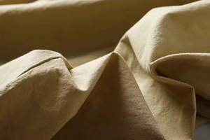Macro texture detail of khaki linen fabric showing natural weave pattern and soft wrinkles